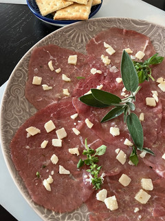 Una foto de Carpaccio de vacuno con salsita de limón y parmesano