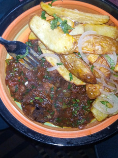 A picture of Beef stew served with 🥔 wedges.