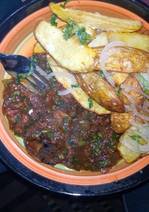 A picture of Beef stew served with 🥔 wedges.