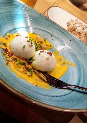Una foto de Huevos fundidos con salsa de quéso cheddar