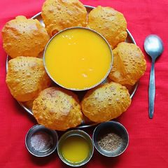 A picture of Fresh Mango Juice and Masala Puri.