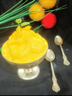 A picture of Mango dessert with small rasgulla.