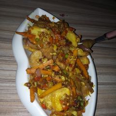 A picture of Fried potetos and veg. sauce.