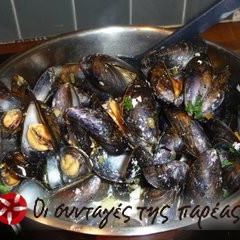 A picture of Steamed mussels with various herbs.