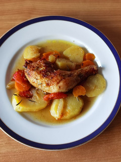 Una foto de Muslos de pollo con patatas y tomate