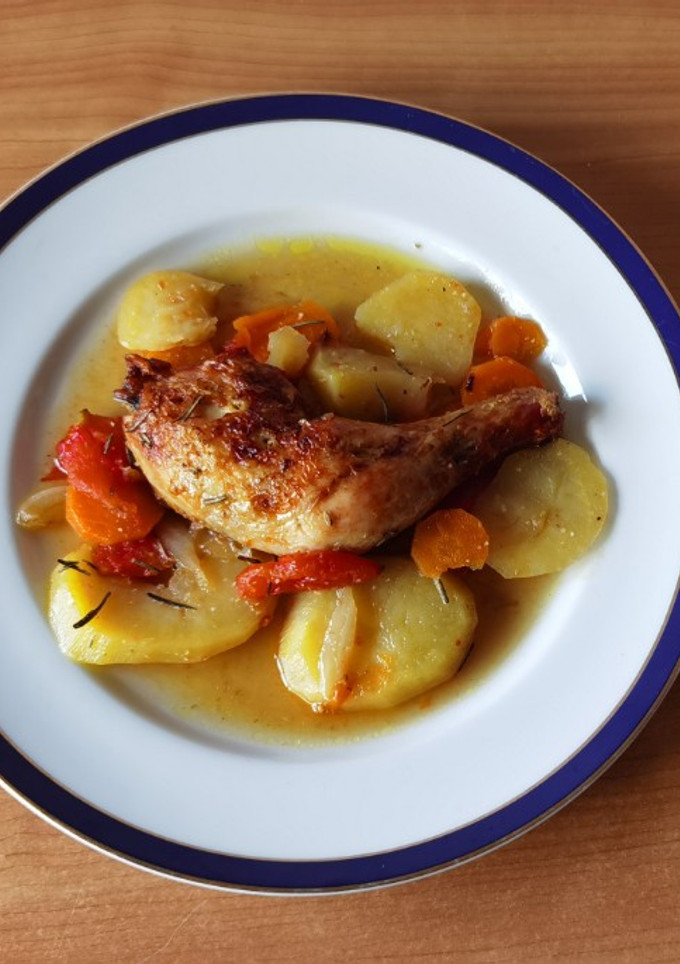 Una foto de Muslos de pollo con patatas y tomate