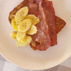 A picture of French toast with bacon and caramelized bananas.