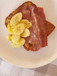 A picture of French toast with bacon and caramelized bananas.