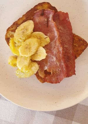 A picture of French toast with bacon and caramelized bananas.
