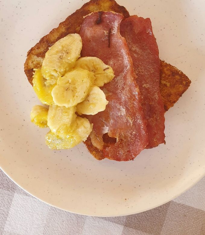 A picture of French toast with bacon and caramelized bananas.