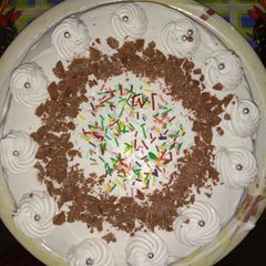 A picture of Ice cake with topping of sprinkles and chocos.