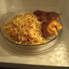 A picture of Fried spaghetti with coated chicken.
