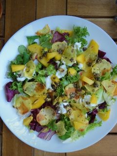 Una foto de Ensalada de melocotón, chips de patata y pistachos