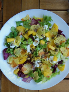 Una foto de Ensalada de melocotón, chips de patata y pistachos