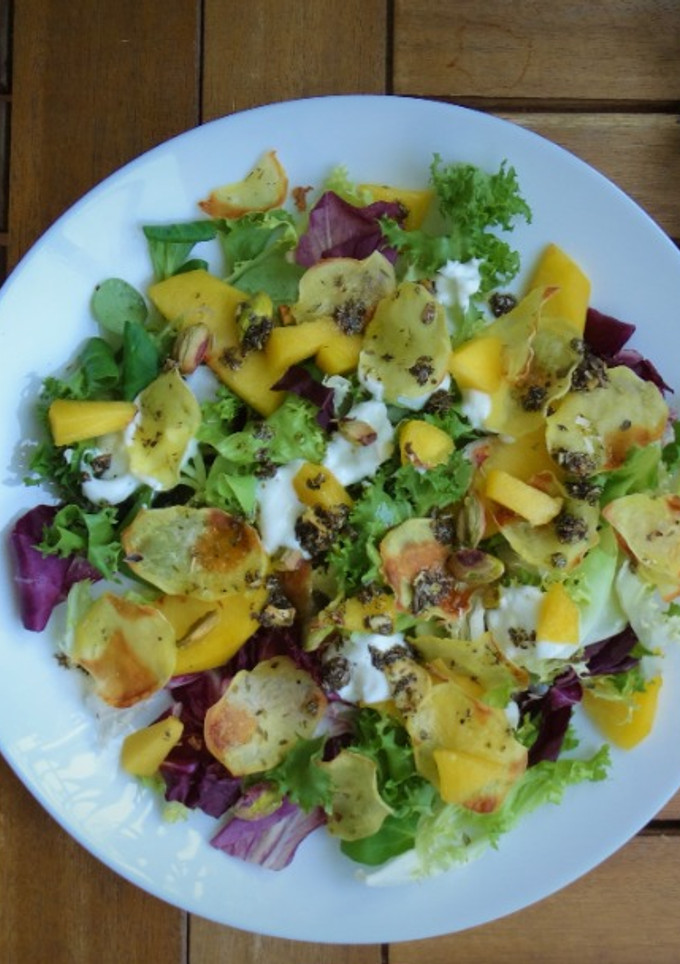 Una foto de Ensalada de melocotón, chips de patata y pistachos