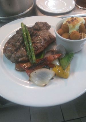 Una foto de Bife de chorizo de 400gr con vegetales asados y papa gratinada