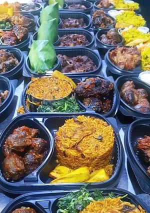 A picture of Jollof rice with fried Gizzard and vegetable.