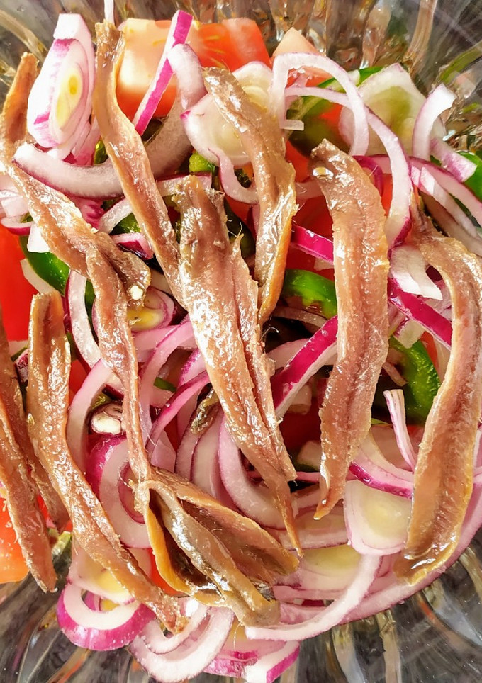 Una foto de Ensalada de tomate, cebolla roja y anchoas