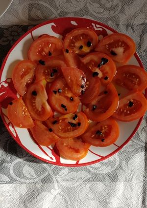 Una foto de Ensalada de tomate y ajo negro