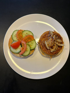 Una foto de 🌱 Bagel con hamburguesa de tofu y cebolla caramelizada 🌱