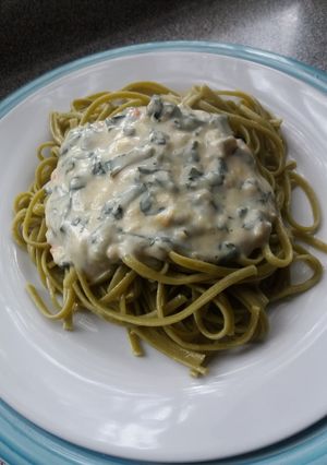 Una foto de Fideos de espinaca con salsa blanca y espinacas