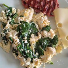 A picture of Spinach Scrambled Eggs with Bacon Medallions.