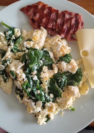 A picture of Spinach Scrambled Eggs with Bacon Medallions.