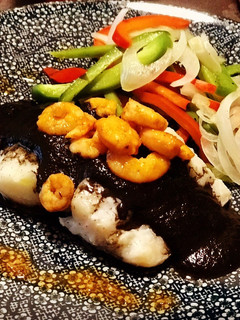 Una foto de Bacalao en papillote con tinta de calamar, gambas picantes y un toque de humo