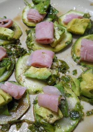 Una foto de Rodajas de zuquini, jamón, palta - tomate, albahaca y algo más.