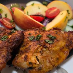 A picture of Chicken thighs with peaches.