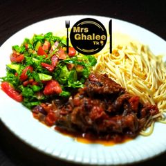 A picture of Pasta with tomatoes sauce and salad.