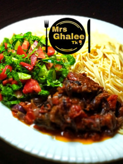 A picture of Pasta with tomatoes sauce and salad.