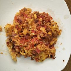 A picture of Scrambled eggs with tomatoes.
