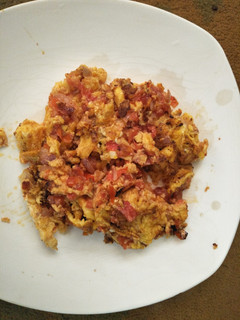 A picture of Scrambled eggs with tomatoes.