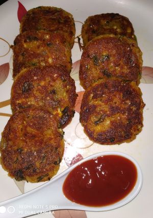 A picture of Aloo tikki with tomato sauce.