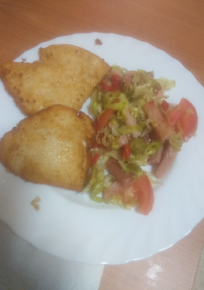 Una foto de Pechuga de pollo empanada con ensalada con bacon frito
