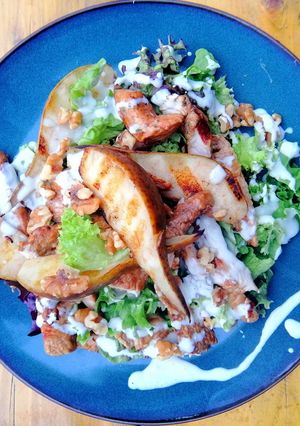 A picture of Grilled turkey, pear and walnut salad with blue cheese dressing.