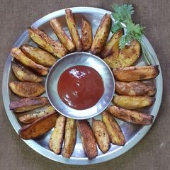 A picture of Baked potato wedges with cheese and herbs.