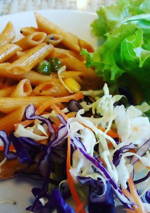 A picture of Indian style corn mutter Penne pasta with salad.