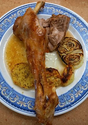 Una foto de Pierna de cordero lechal al horno con patatas y cebolla