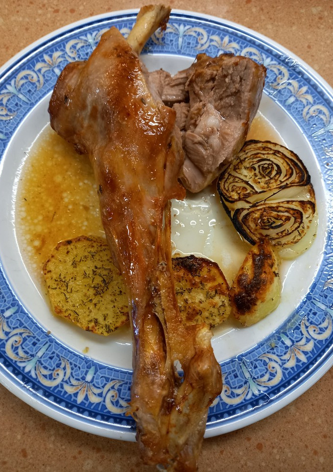 Una foto de Pierna de cordero lechal al horno con patatas y cebolla
