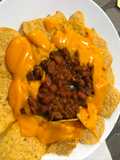 Chile de carne de cerdo y nachos con salsa de queso fundido
