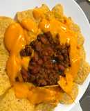 Chile de carne de cerdo y nachos con salsa de queso fundido