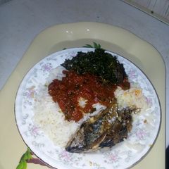 A picture of Rice and stew with fish and veggies.