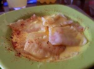 Una foto de Raviolones de merluza y Kanikama, con crema de azafrán