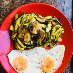 A picture of Courgette noodles,on pesto with mushrooms-Fried eggs.