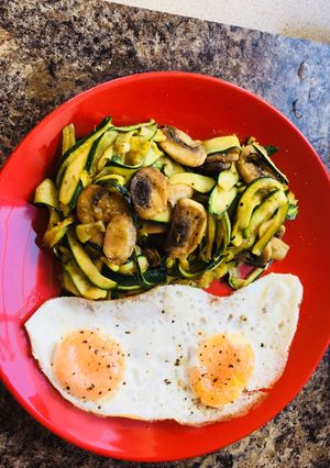 A picture of Courgette noodles,on pesto with mushrooms-Fried eggs.