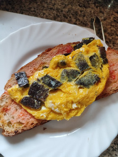 Una foto de Tortilla francesa con bull negro y pan con tomate al punto picante