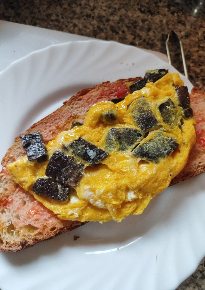 Una foto de Tortilla francesa con bull negro y pan con tomate al punto picante