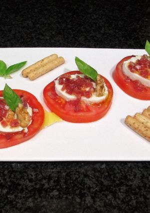 Foto principal de Rodajas de mozzarella sobre tomates con jamón curado picadito
